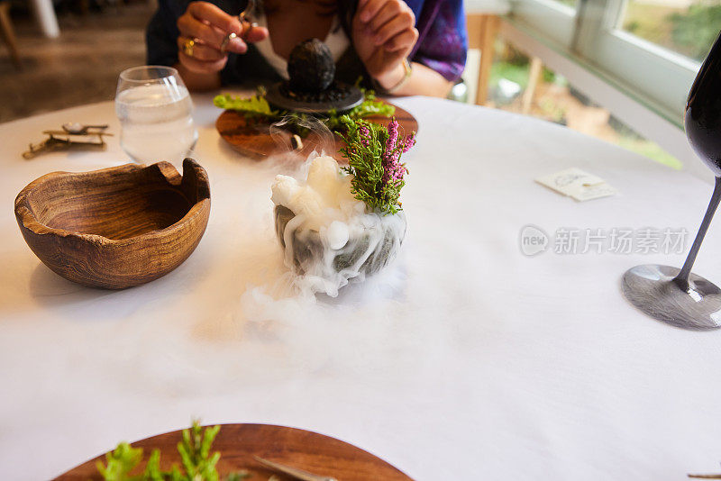 在一家高级餐厅里，客人享受着干冰陪伴的晚餐