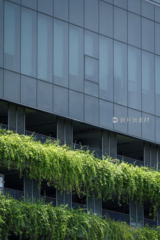 外部不确定的现代建筑立面与绿色垂直花园走廊上可持续建筑商业设计理念。