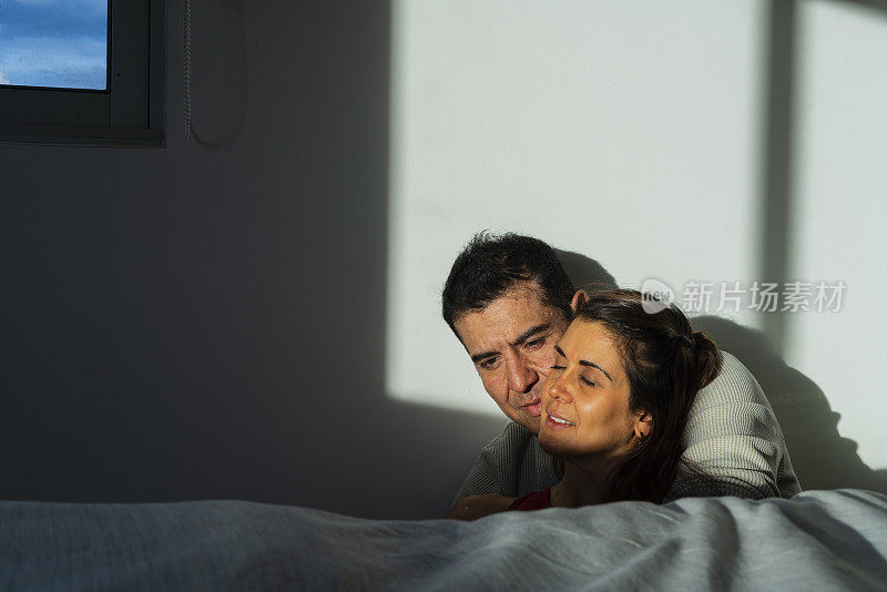异性恋的拉丁裔夫妇在他们家的房间里拥抱着复活的阳光