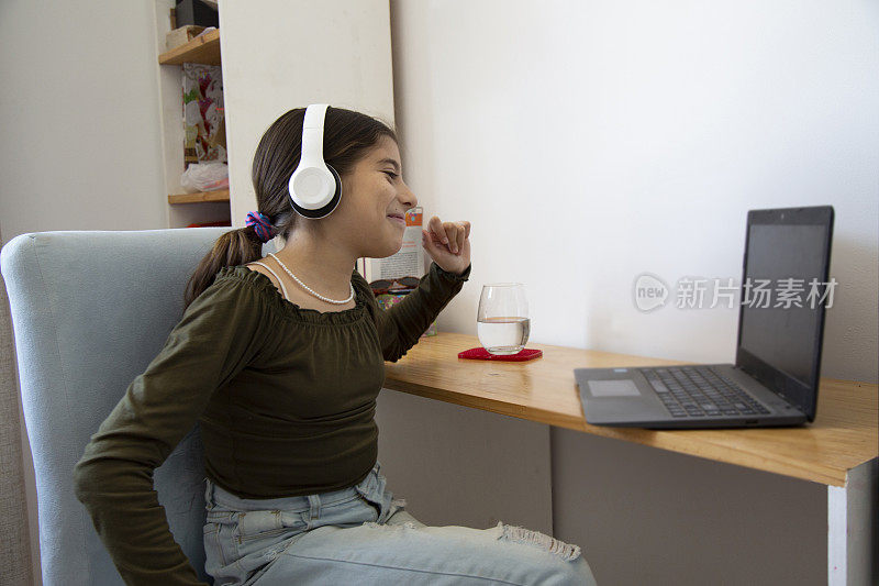 一个女孩看着听着她的笔记本电脑