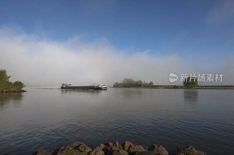 货运船在一个雾蒙蒙的早晨日出在艾瑟尔三角洲景观在上艾瑟尔