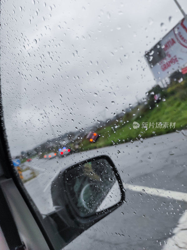 在一个下雨天开车，透过窗户看到一辆警车和一辆撞坏的汽车