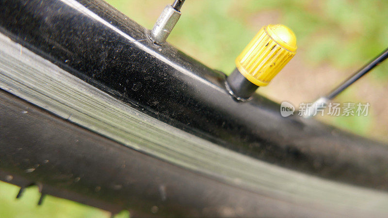 自行车轮子，特写镜头。自行车配件:轮胎内胎盖，侧角。自行车轮胎。骑自行车
