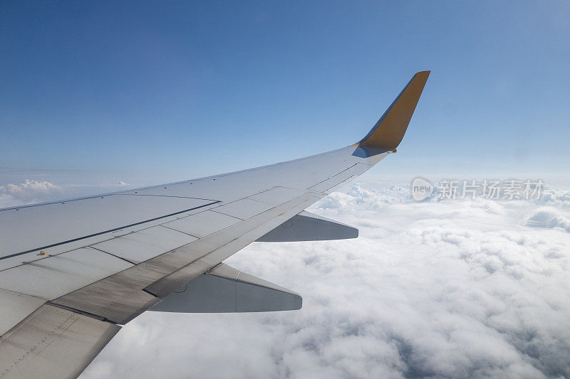 飞机的机翼在天空的云层上飞行