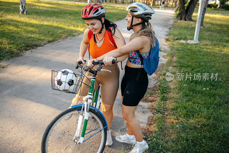 朋友们在城市公园里学习如何骑自行车