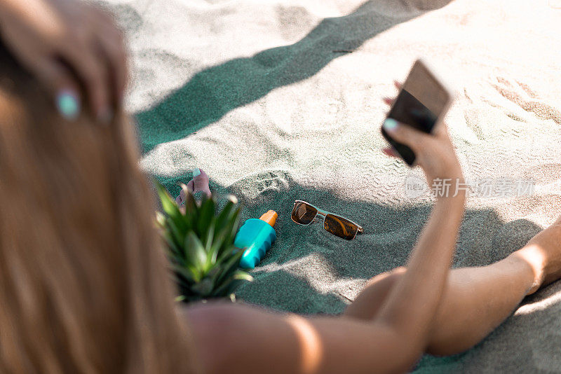 年轻迷人的女人在热带海滩自拍，库存照片