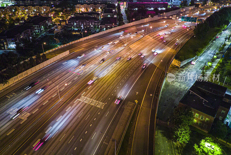 夜间照明的高速公路动脉:夜间高架道路上繁忙的交通。亚特兰大市中心连接器，GA。鸟瞰图，长曝光