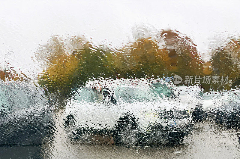 停在被雨水淋湿的停车场里的汽车