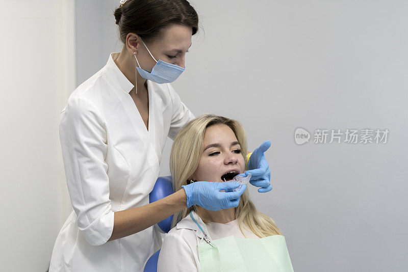 牙科医生在塑料托盘上制作牙模，正畸治疗概念
