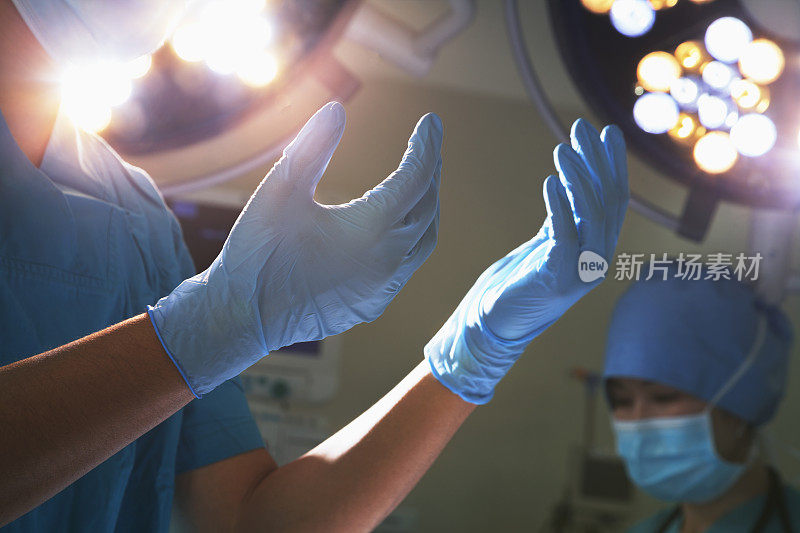 腹部视图的手在外科手套和灯