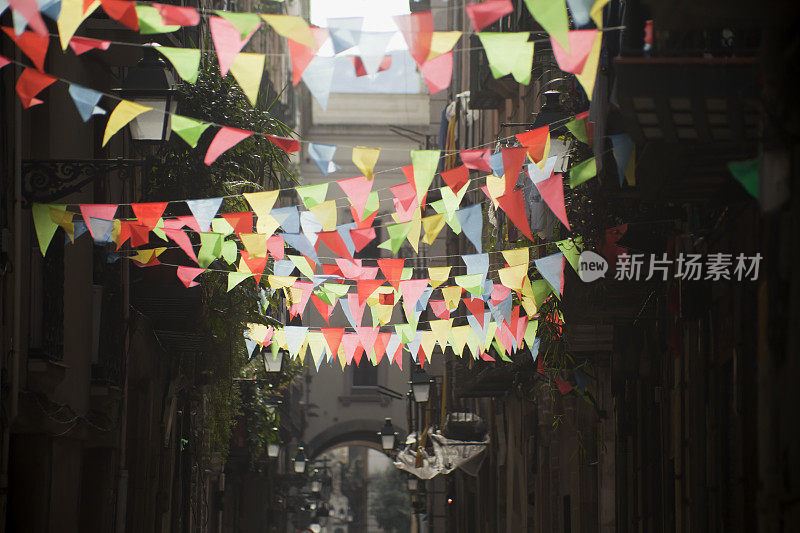 五彩缤纷的宴会装饰背光在一条狭窄的街道上。