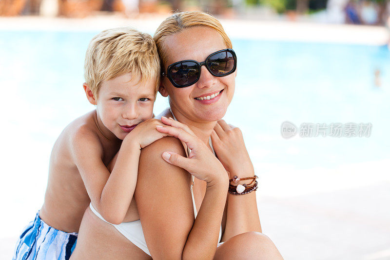母亲和儿子在泳池边休息