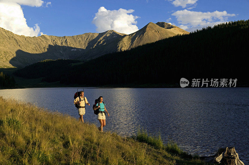 一对夫妇在湖边的山上徒步旅行