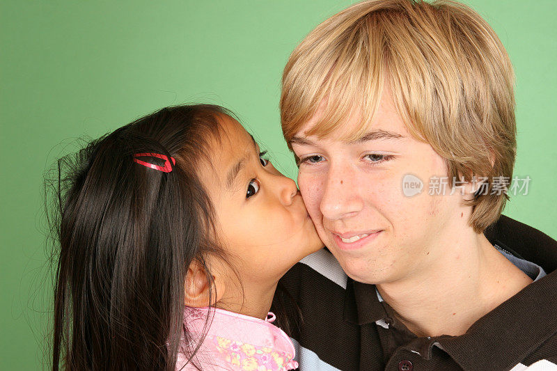 一个中国小女孩在亲吻她的弟弟