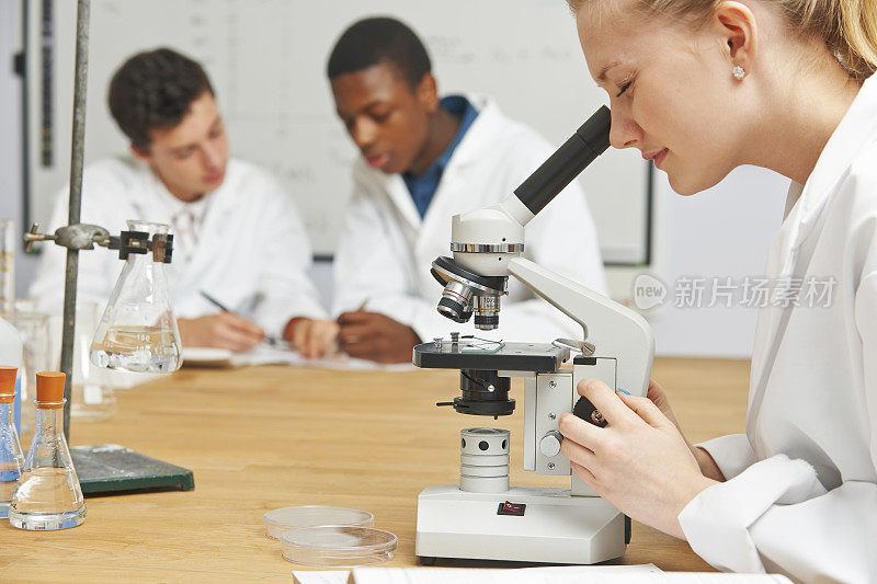 青少年学生在科学课上使用显微镜