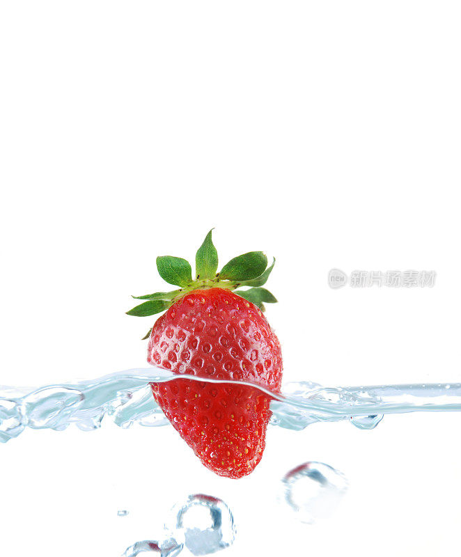 新鲜的草莓掉进水里，白色的草莓上有孤立的气泡
