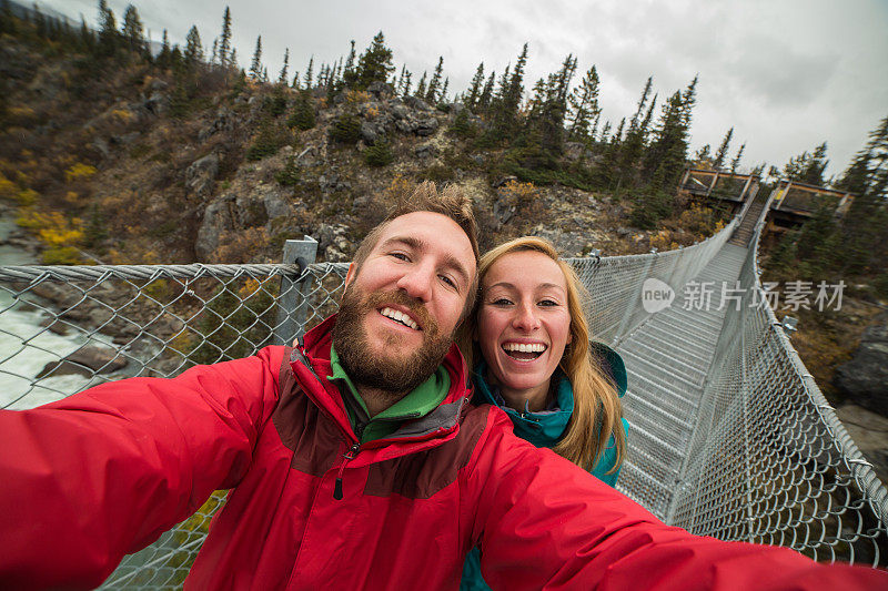 一对年轻夫妇在吊桥上自拍。