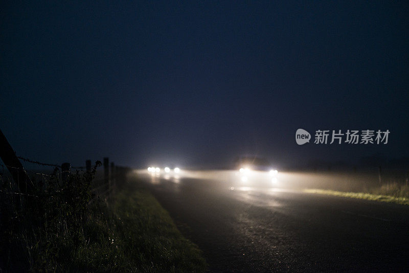 夜间浓雾弥漫的乡村道路上的车辆分散开来