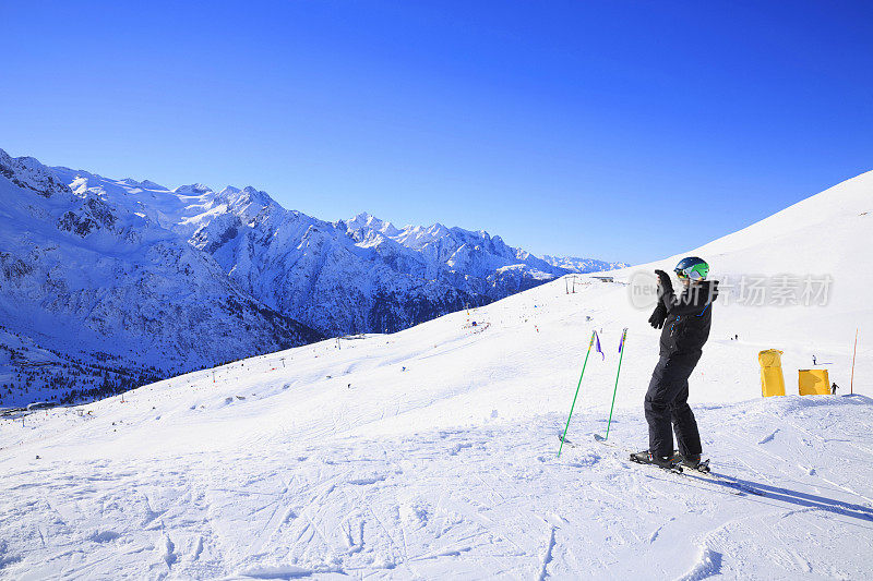 摄影师滑雪者拍摄享受冬季雪山景观