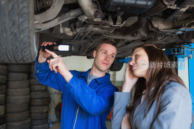 汽车修理工和女人检查汽车轮胎