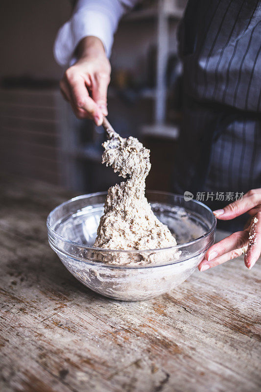 为自制面包混合配料的女人。