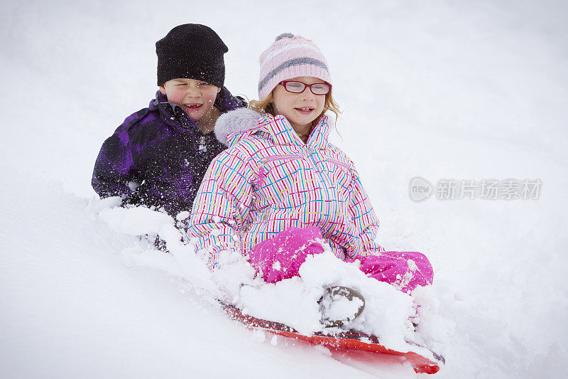 孩子们在冬天玩雪橇。