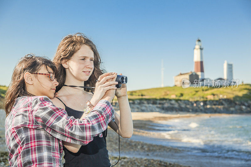 两姐妹，少女，用双筒望远镜探索海洋