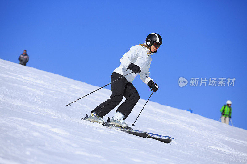 在阳光明媚的滑雪胜地滑雪的中年妇女滑雪