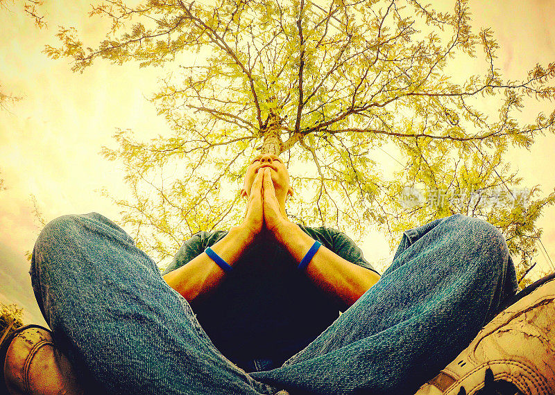 一个坐在树下祈祷的人