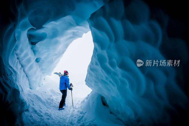 滑雪者探索冰洞。