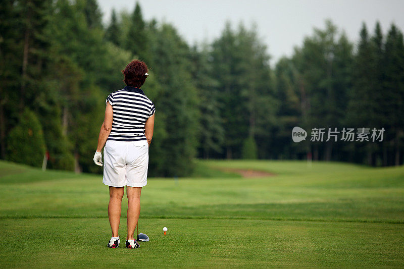 高级女子高尔夫球手在高尔夫球场打球