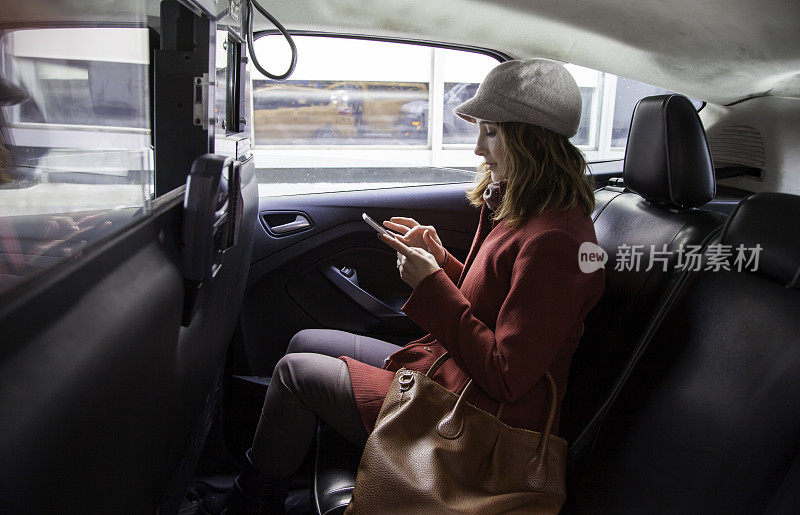 一个女人在出租车上使用手机