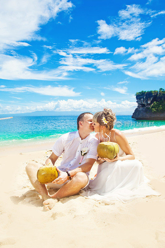 新娘和新郎在海滩上接吻
