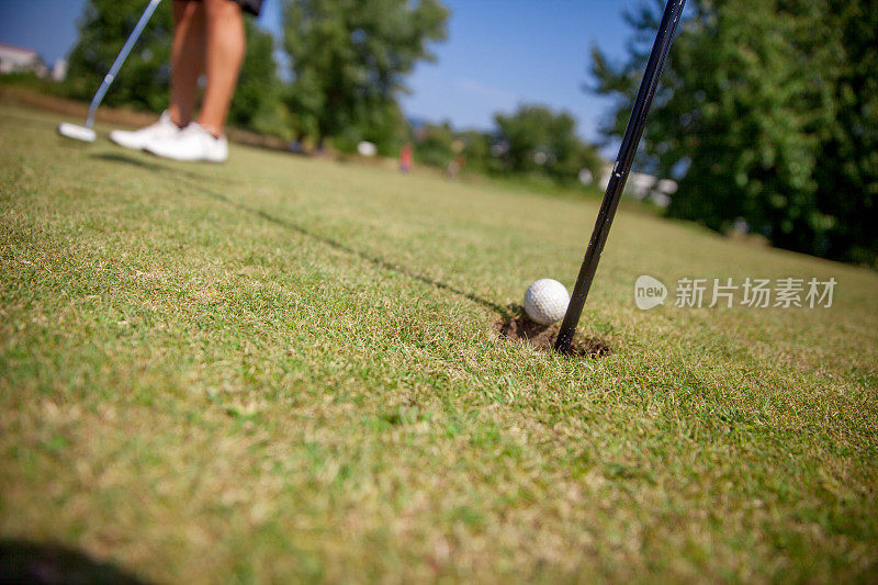 高尔夫球手把高尔夫球放在草地上