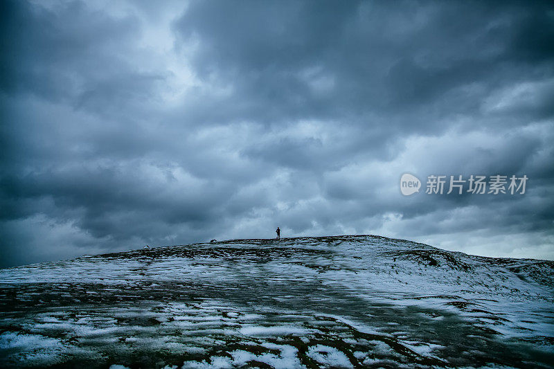 人们在暴风雨天气下在美丽的冬季山脉徒步旅行