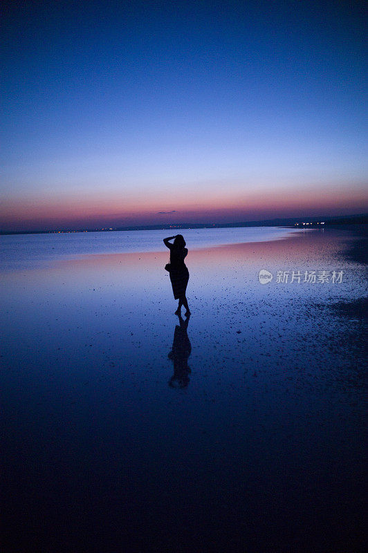 一名女子站在土耳其科尼亚盐湖的日落时分