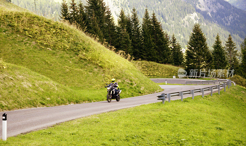 在欧洲阿尔卑斯山的山路上骑摩托车的人