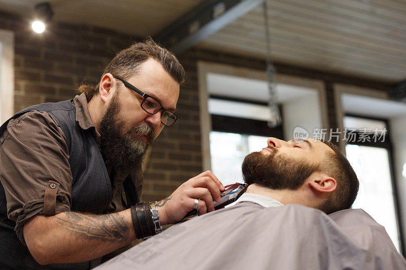 理发师在理发店里给一个男人理发
