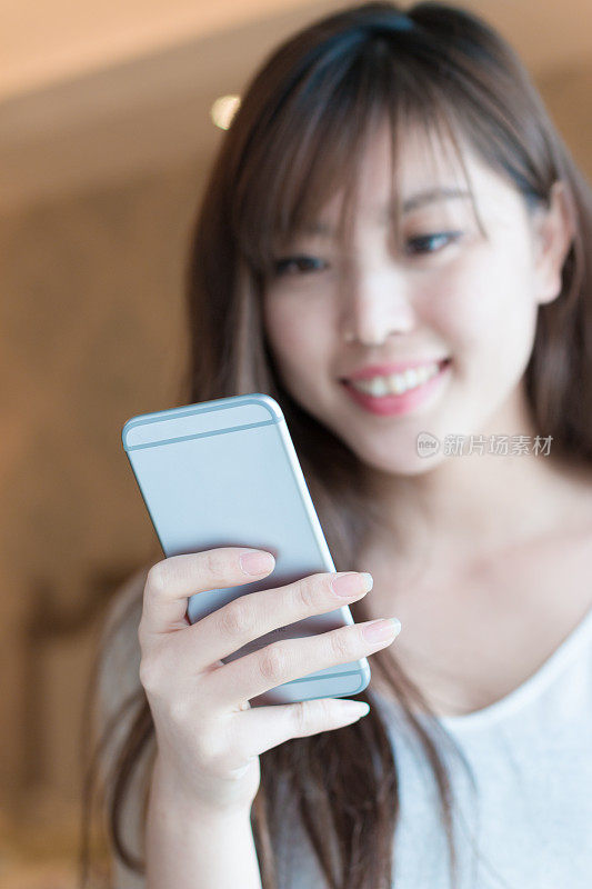 年轻美丽的亚洲女人与手机
