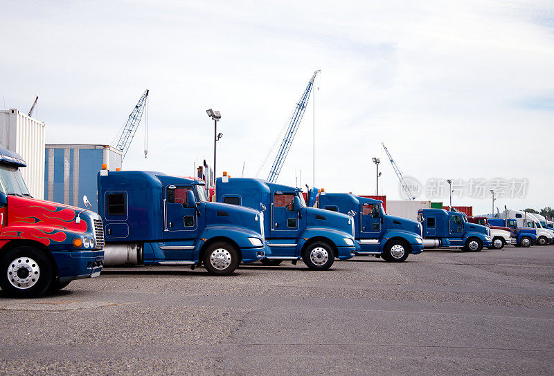 大卡车、半卡车在工业区的大型停车场上排成一排