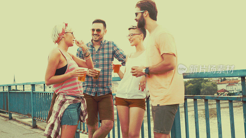 四个游客在桥上喝着当地啤酒