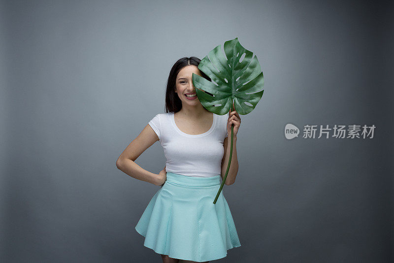 美丽的年轻女子拿着一片叶子