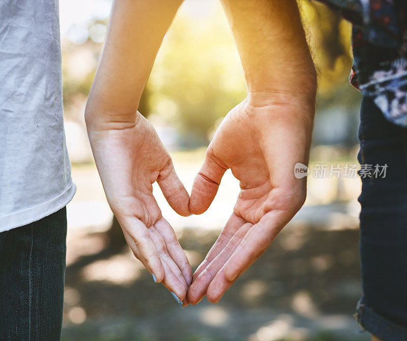 夫妇用手做心形的后视图