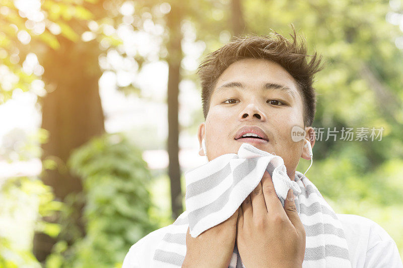 亚洲男性在锻炼后擦拭汗水