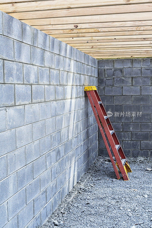 建筑工人的梯子靠在新的混凝土砌块墙上