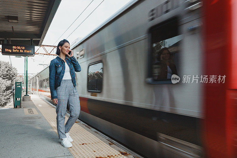 一个女人一边等火车一边打手机