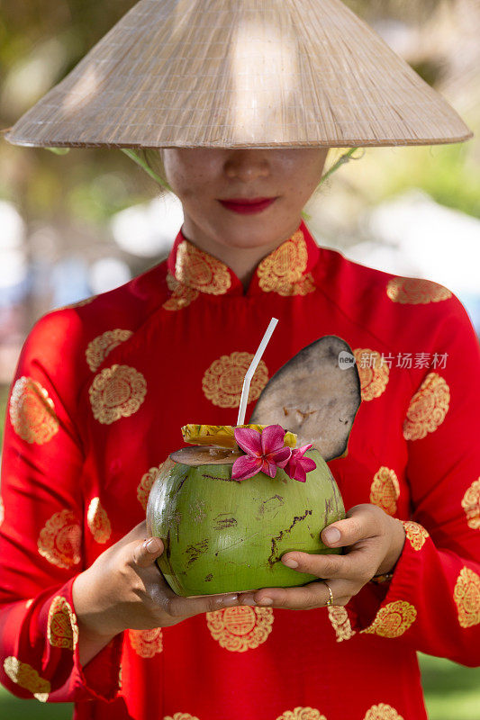 异国情调的传统越南女孩，同时提供新鲜的椰果和鲜花