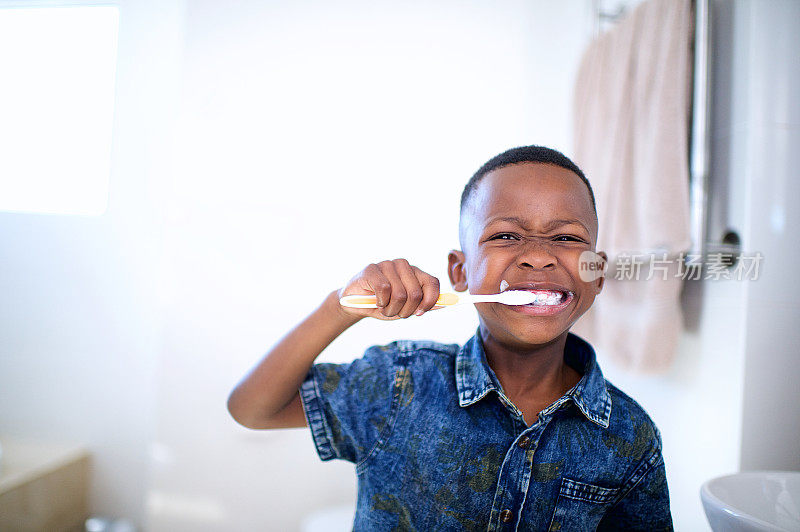 非洲6-7岁男孩正在刷牙，咧嘴笑