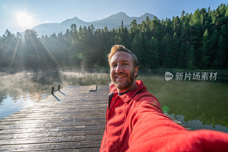 在清晨的雾中，年轻男子在湖码头上的自拍，瑞士