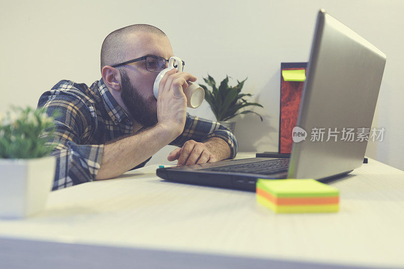 在办公室喝咖啡的疲惫商人